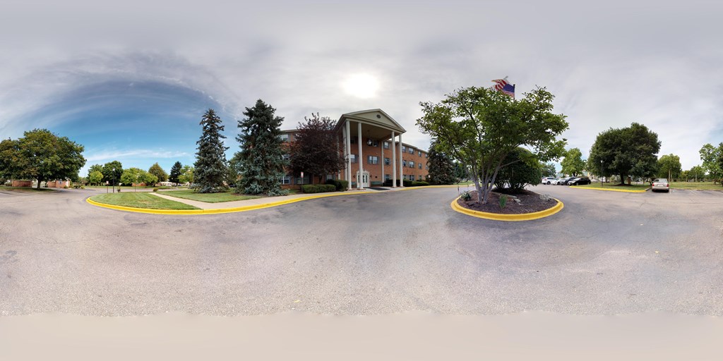 A building with a flag on top and a tree in front of it.