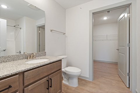 A bathroom with a sink, toilet and a mirror.