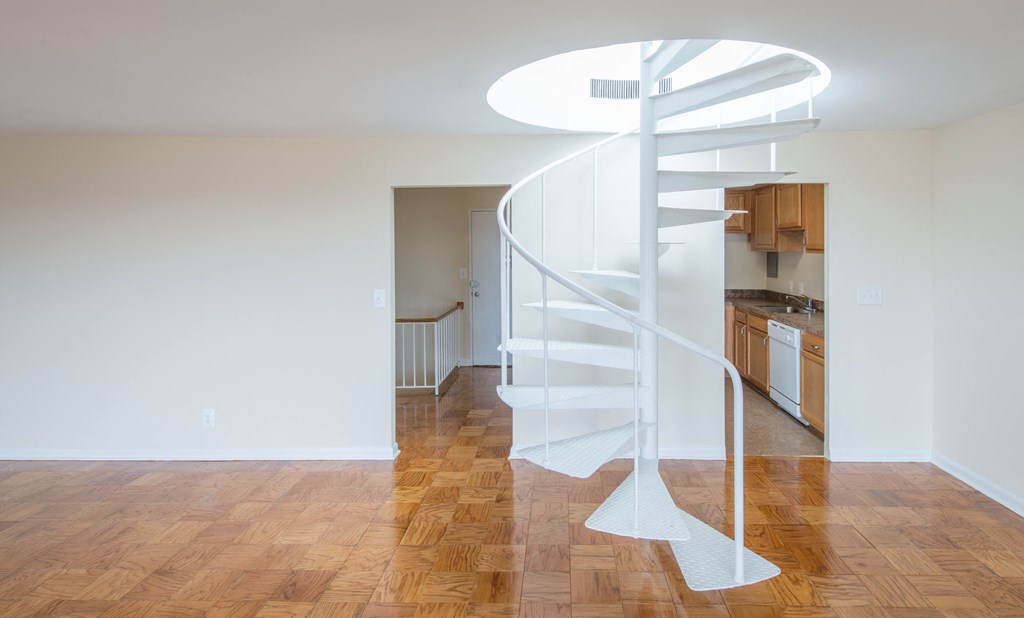 A spiral staircase in a room with wooden floors.
