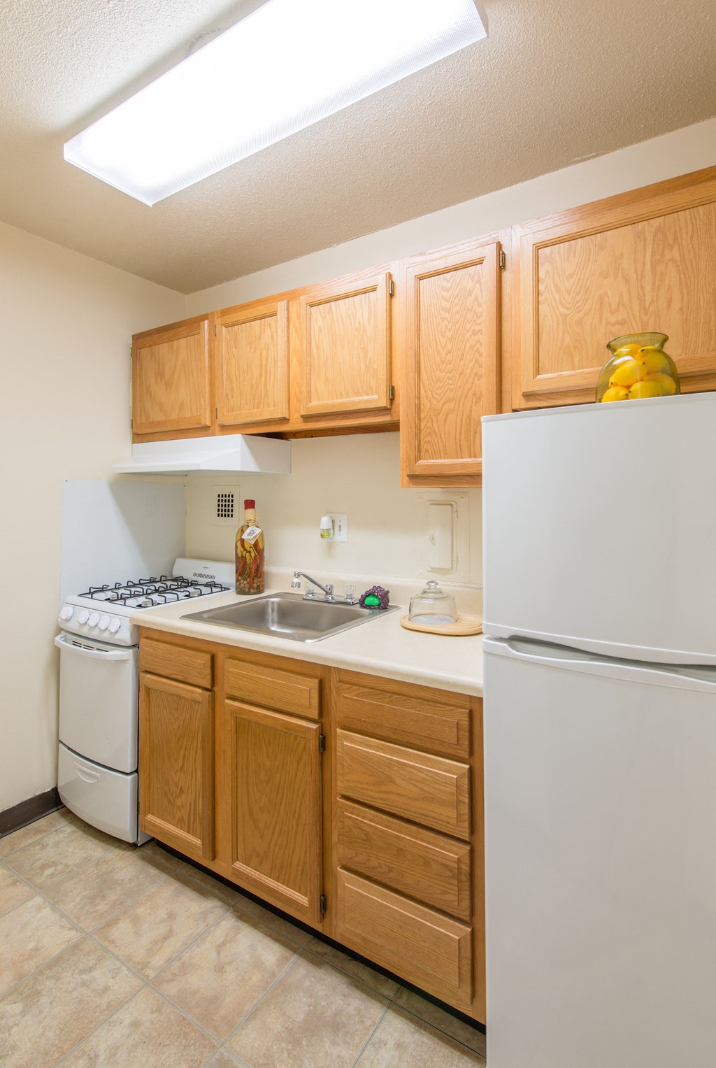 A kitchen with wooden cabinets and a white refrigerator.