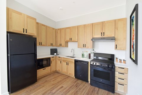 A kitchen with wooden cabinets and black appliances.