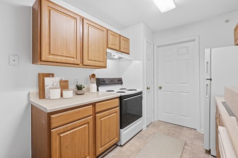 A kitchen with wooden cabinets and a white refrigerator.