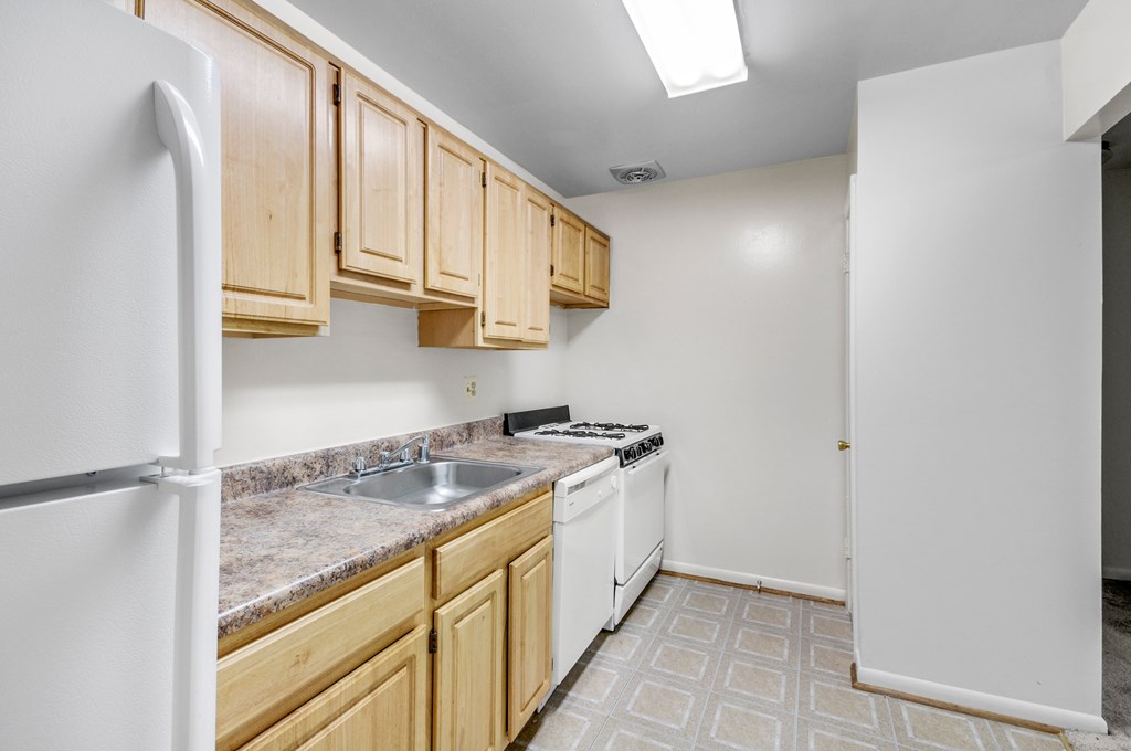 A kitchen with wooden cabinets and a white refrigerator.