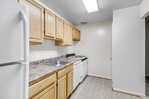 A kitchen with wooden cabinets and a white refrigerator.