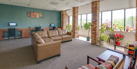 A living room with a brown couch and a television.