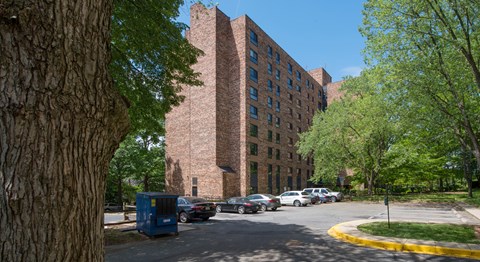 A large brick building is seen in the distance behind a parking lot.