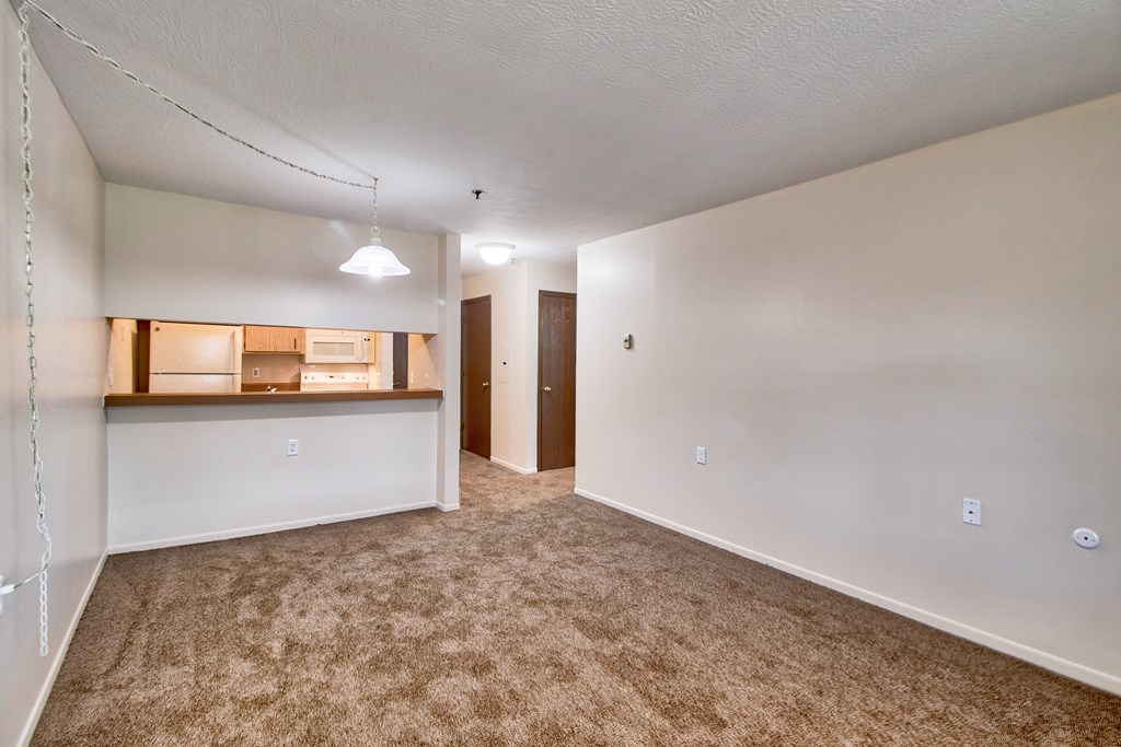 A room with a carpeted floor and a door on the right side.