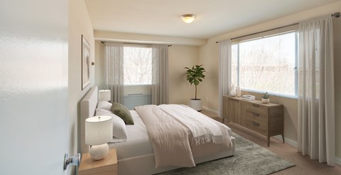 A bedroom with a bed, nightstand, and window.