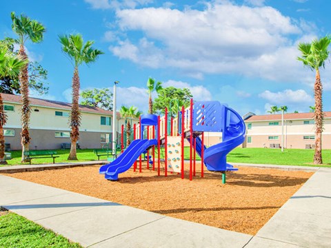 A playground with a blue slide and red and yellow climbing structures.