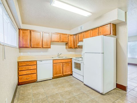 A kitchen with white appliances and wooden cabinets.