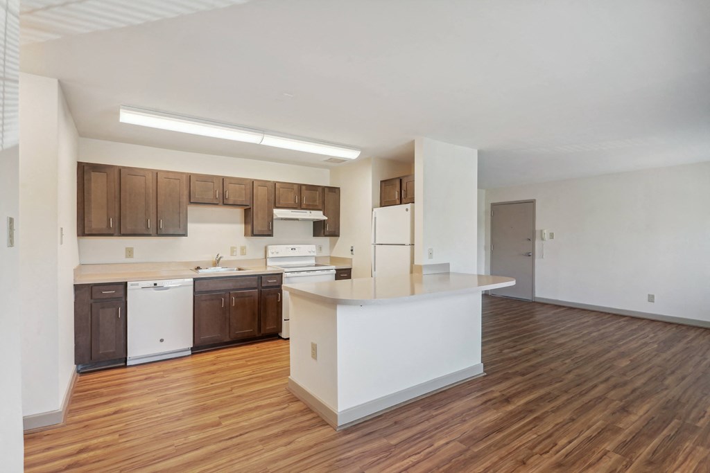 A kitchen with brown cabinets and a white counter.