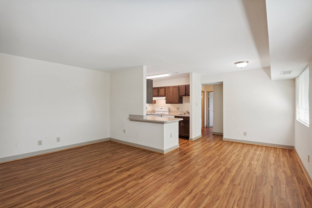 A large empty room with wooden floors and white walls.