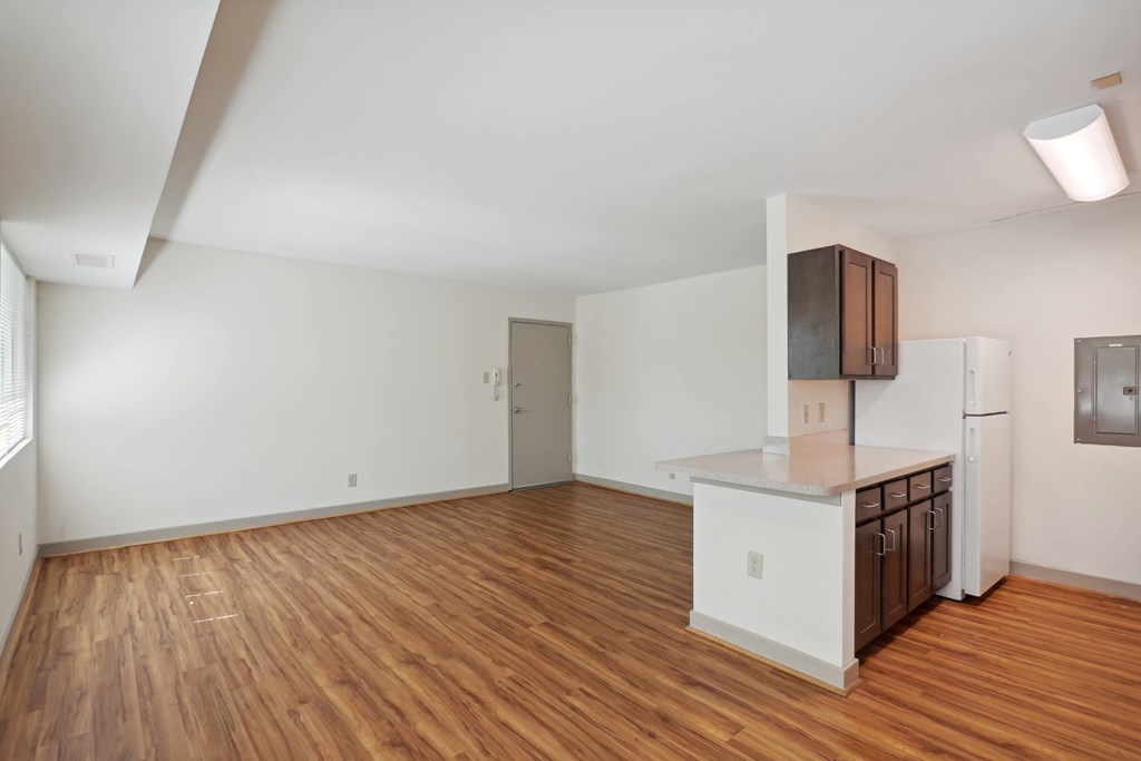 A kitchen with white cabinets and a wooden floor.