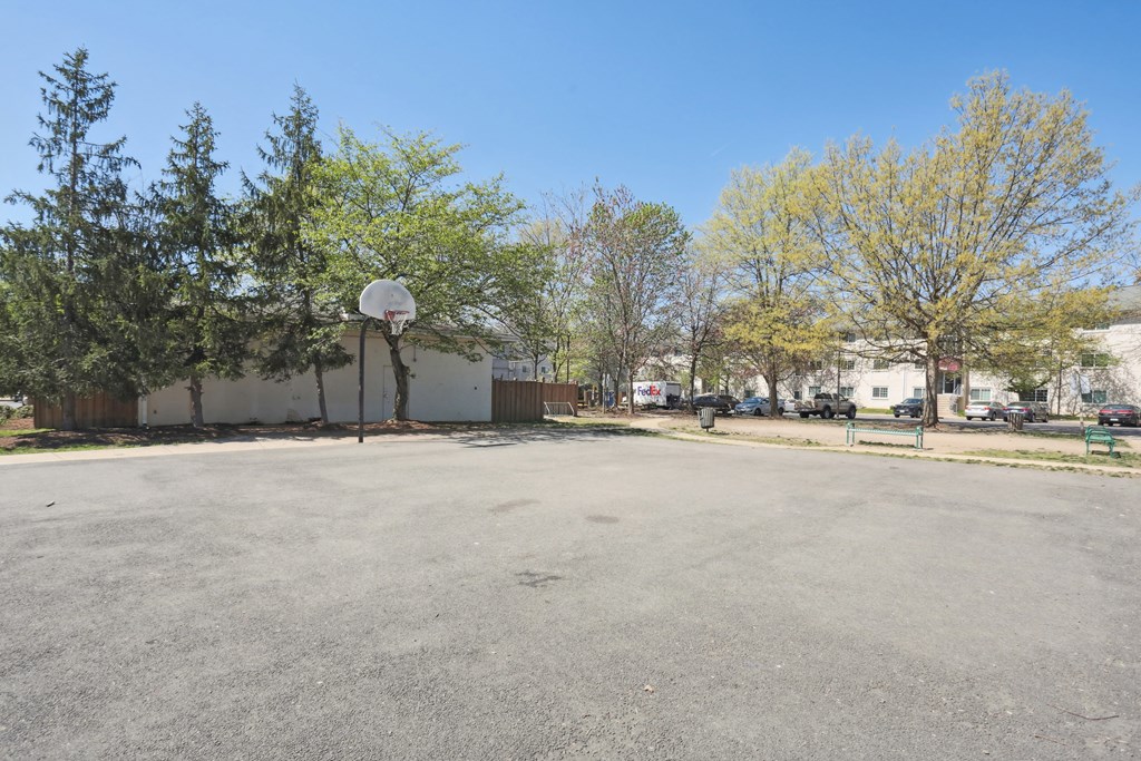 A basketball court with a hoop and a basketball on the ground.