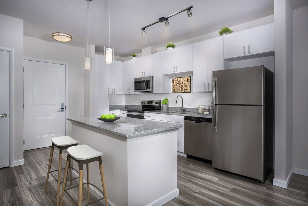 A kitchen with a white island and stools.