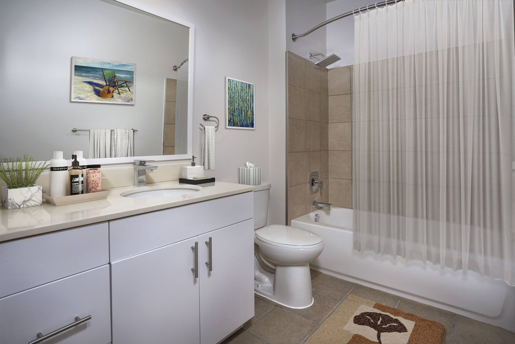 A bathroom with a white toilet, sink, and shower curtain.