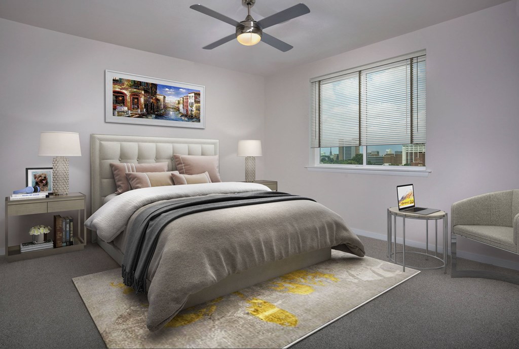 A bedroom with a large bed, a ceiling fan, and a window with a view of the city.