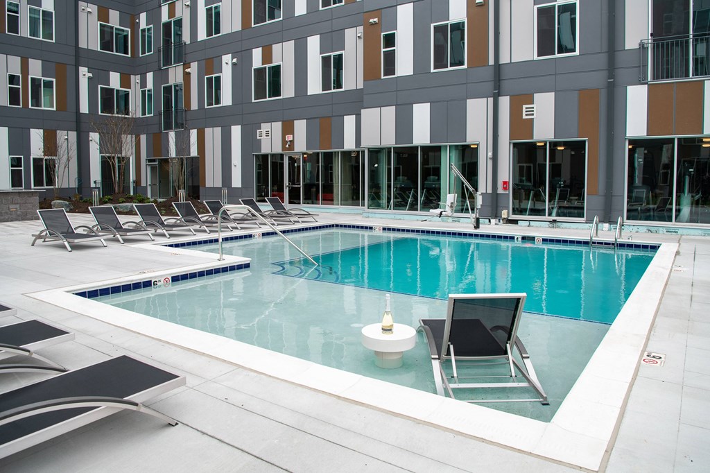 A swimming pool with a chair and a table in the middle of it.