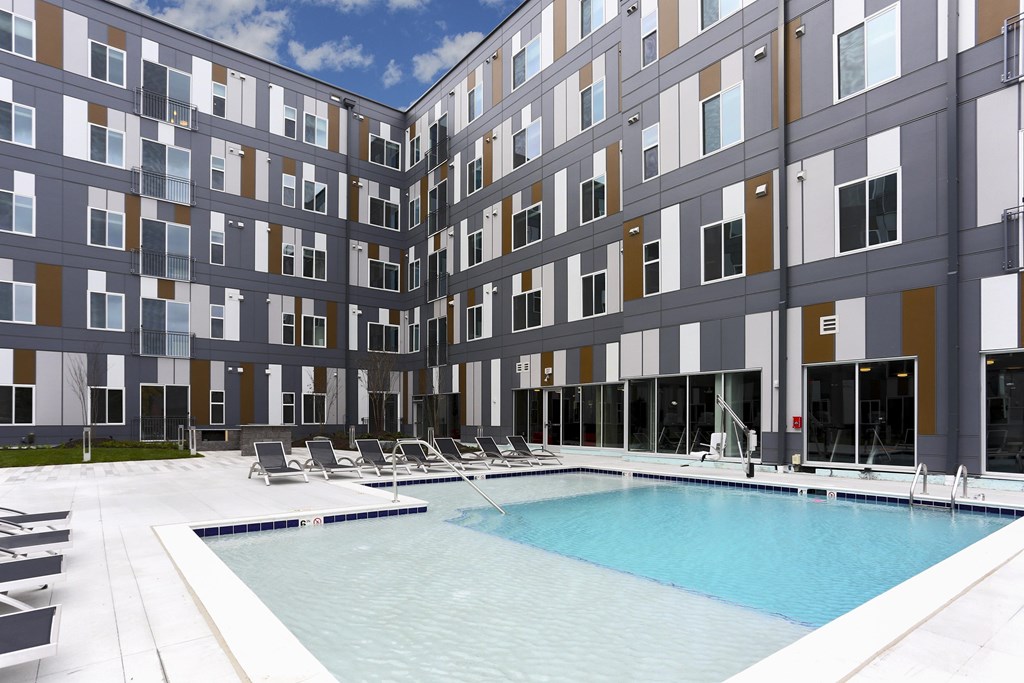 A large indoor swimming pool in front of a multi-story building.