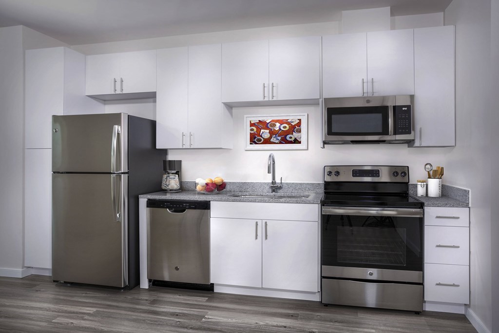 A modern kitchen with stainless steel appliances and white cabinets.