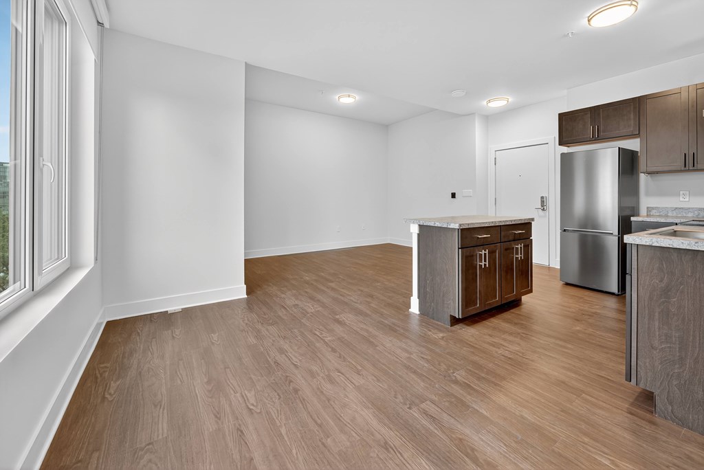 A kitchen with a refrigerator, sink, and cabinets.