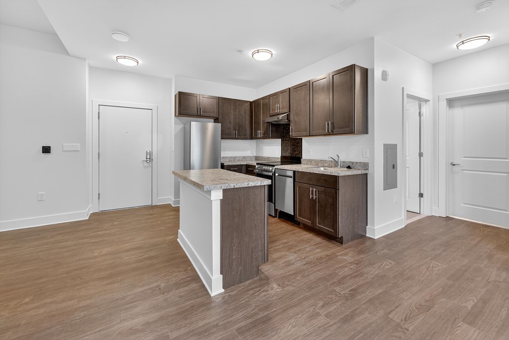A kitchen with a white island and wooden floors.