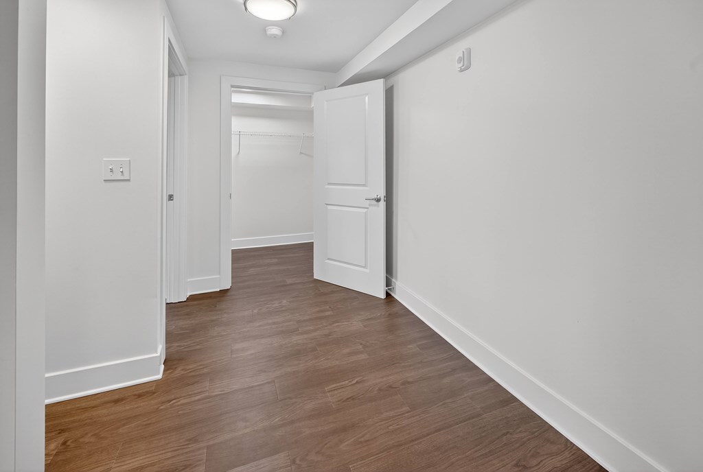 A long hallway with a white door at the end.