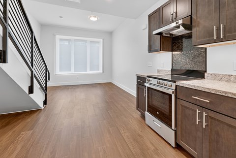 A kitchen with a stainless steel oven and wooden cabinets.