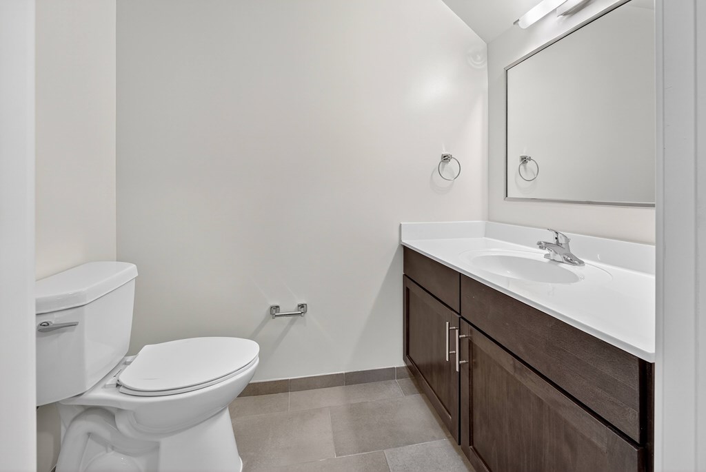 A white toilet sits next to a sink in a bathroom.