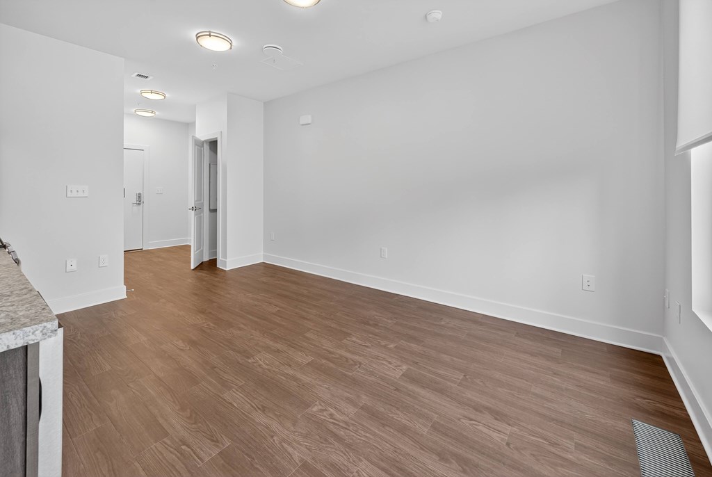 A room with wooden flooring and white walls.
