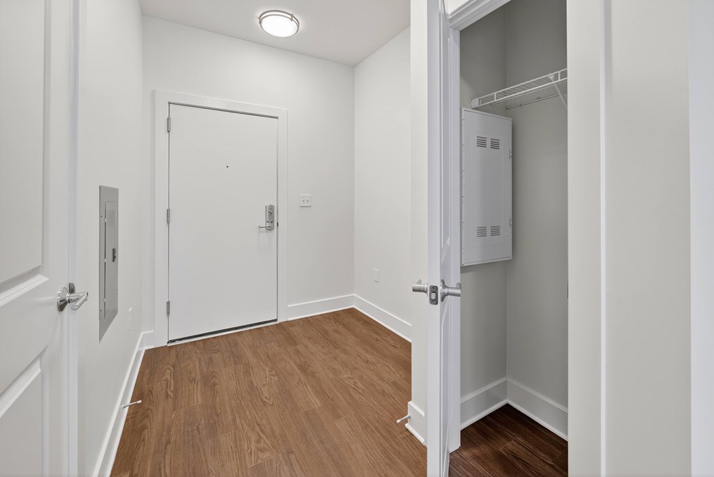 A white door is open to a small white closet.