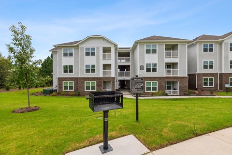A black mailbox stands in front of a building with a sign on it.