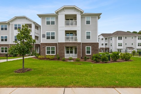 A large apartment complex with a well-maintained lawn in front.