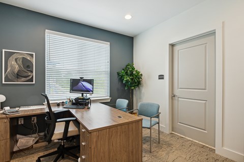 A room with a desk, chair, and computer.