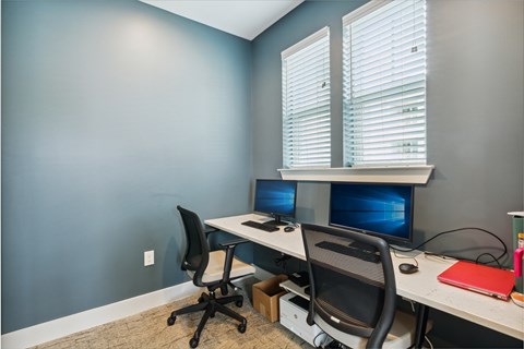 A room with two computers and two chairs.
