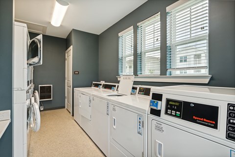 A laundry room with washing machines and a dryer.