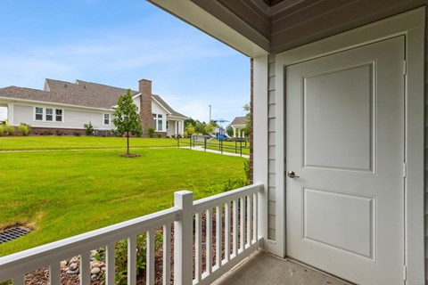 A white door is on the porch of a house.