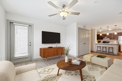 A living room with a flat screen TV mounted on the wall.