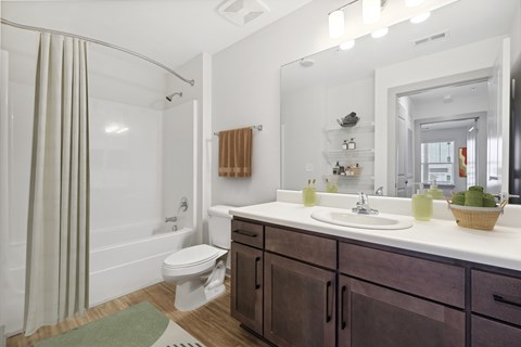 A bathroom with a white sink, a white toilet, and a white tub with a shower curtain.