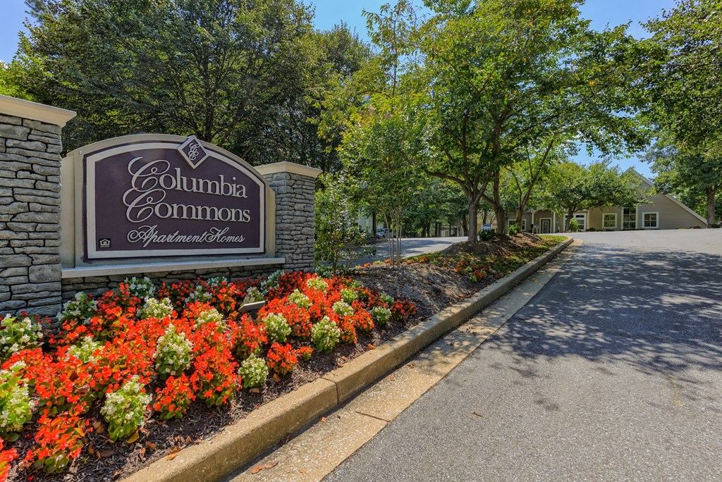 a sign commons sits in front of a garden of flowers