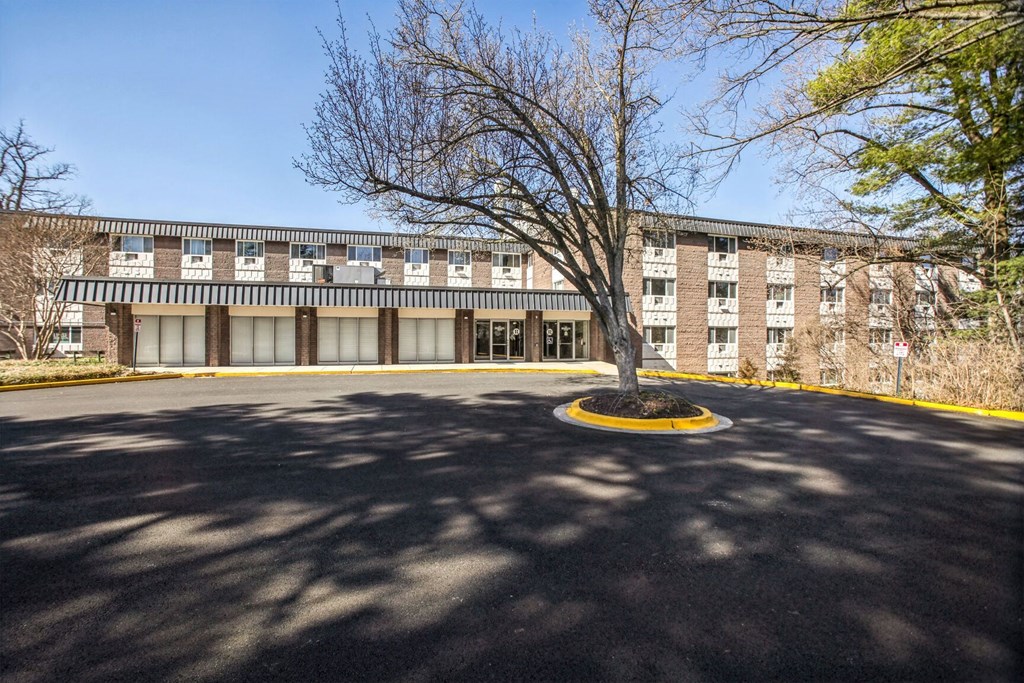 the front of a brick building with a tree in front of it