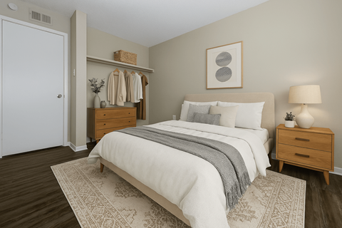 A bedroom with a large bed and a wooden nightstand.