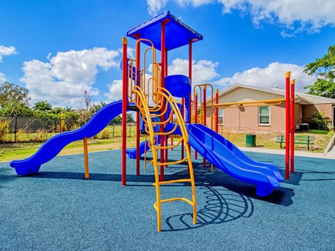 A playground with a blue slide and a yellow structure.