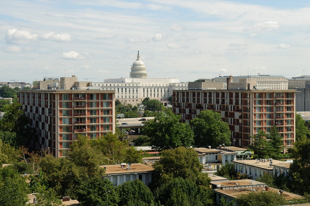 A view of the Capitol building from a distance with trees in the foreground.