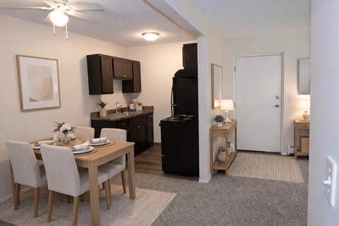 A kitchen with a dining table and chairs.