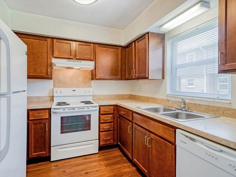A kitchen with wooden cabinets and white appliances.
