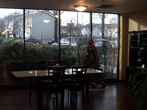 A dining room with a table and chairs and a Christmas tree.