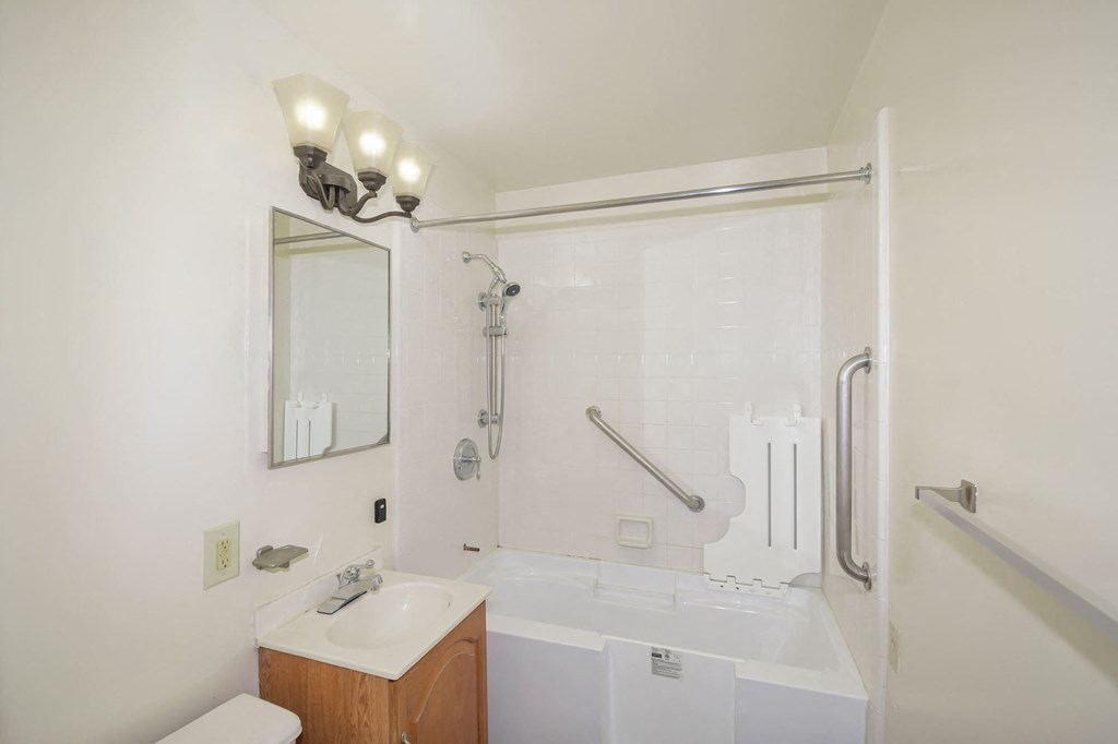 A white bathroom with a toilet, sink, and bathtub.