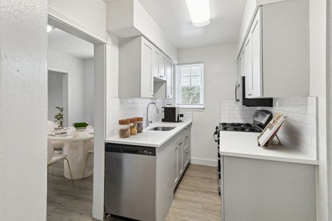 A modern kitchen with white cabinets and a stainless steel dishwasher.