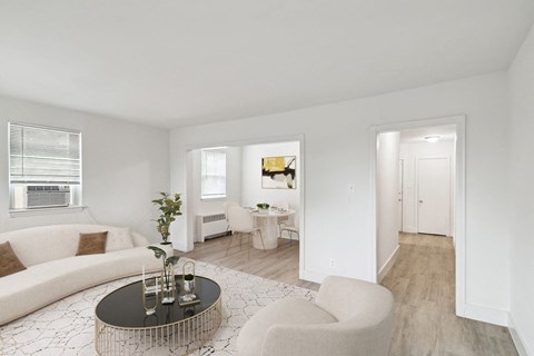 A living room with a white couch, a coffee table, and a chair.